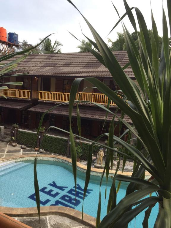 a resort with a swimming pool and a house at Grand Desa Resort in Cimaja
