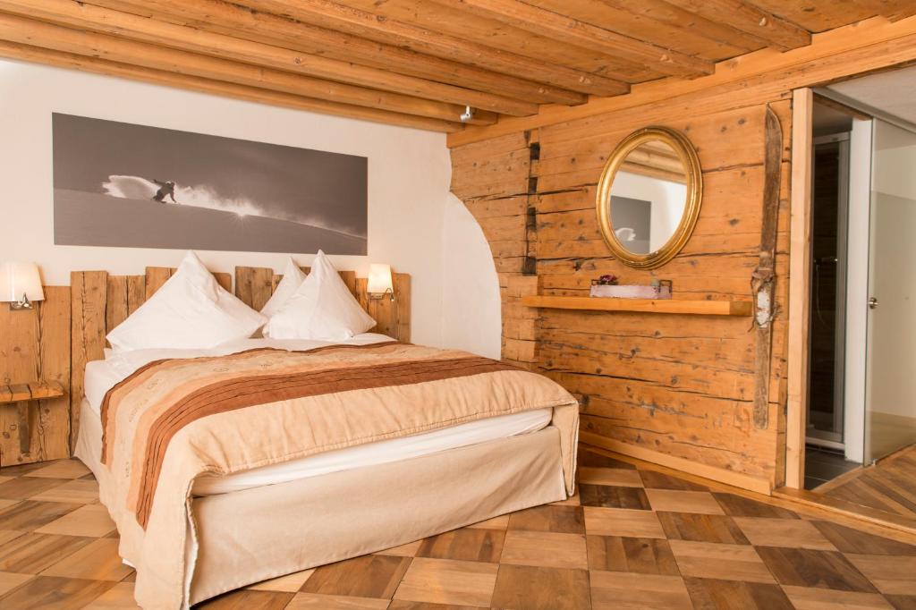 a bedroom with a bed and a mirror at Boutique Hotel The River House in Andermatt