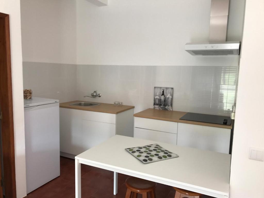 a white kitchen with a table and a sink at Europa Apart in Castanheira de Pêra