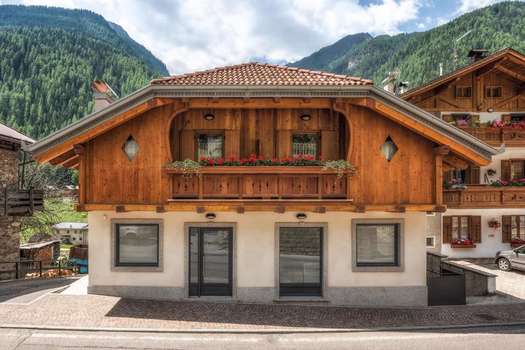 una casa de madera con un balcón con flores. en Casa Elena, en Rabbi