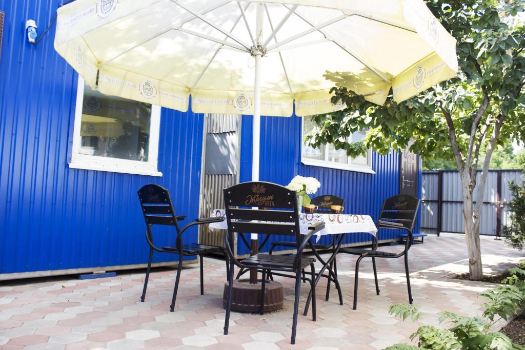 a table and chairs under an umbrella on a patio at Dacha v Odesse in Odesa
