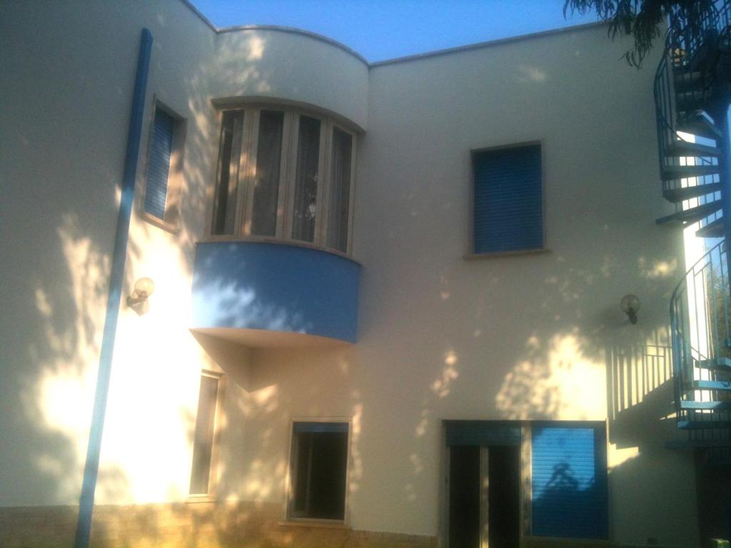 Una casa blanca con un balcón en el lateral. en Blu Mare Villa Carlo, en Anzio