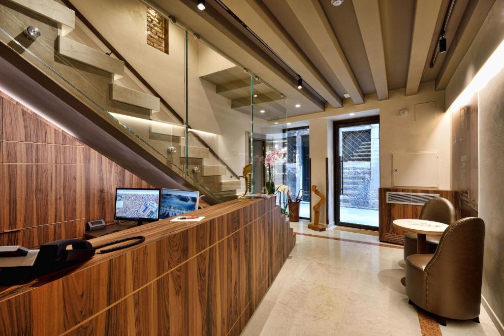 ヴェネツィアにあるロサ サルバ ホテルの受付カウンターとデスクのあるオフィス