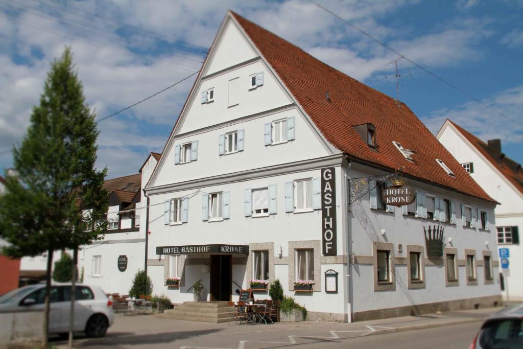a large white building with a brown roof at Hotel Gasthof Krone in Zusmarshausen