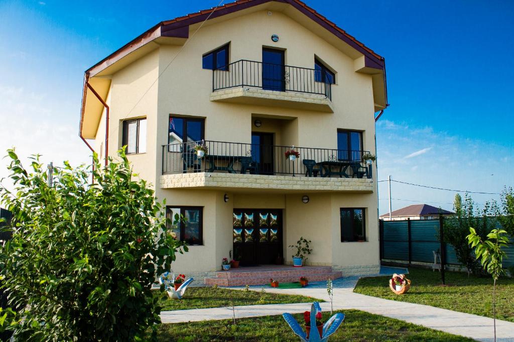 a large house with a balcony and a yard at Casa La Flori in Techirghiol