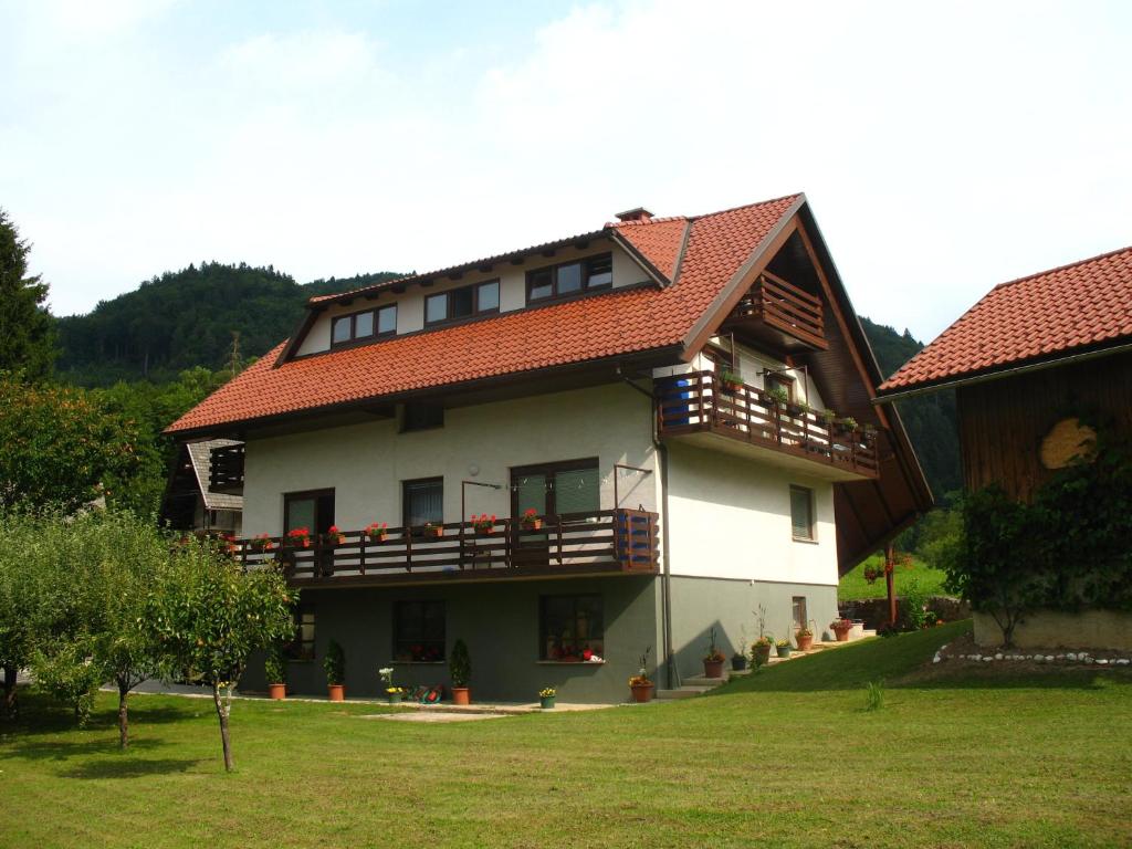 ein großes Haus mit rotem Dach in der Unterkunft Rooms Zupančič in Bohinjska Bela