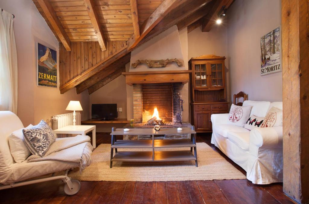 a living room with a couch and a fireplace at Tarter Chalets Apartaments in El Tarter