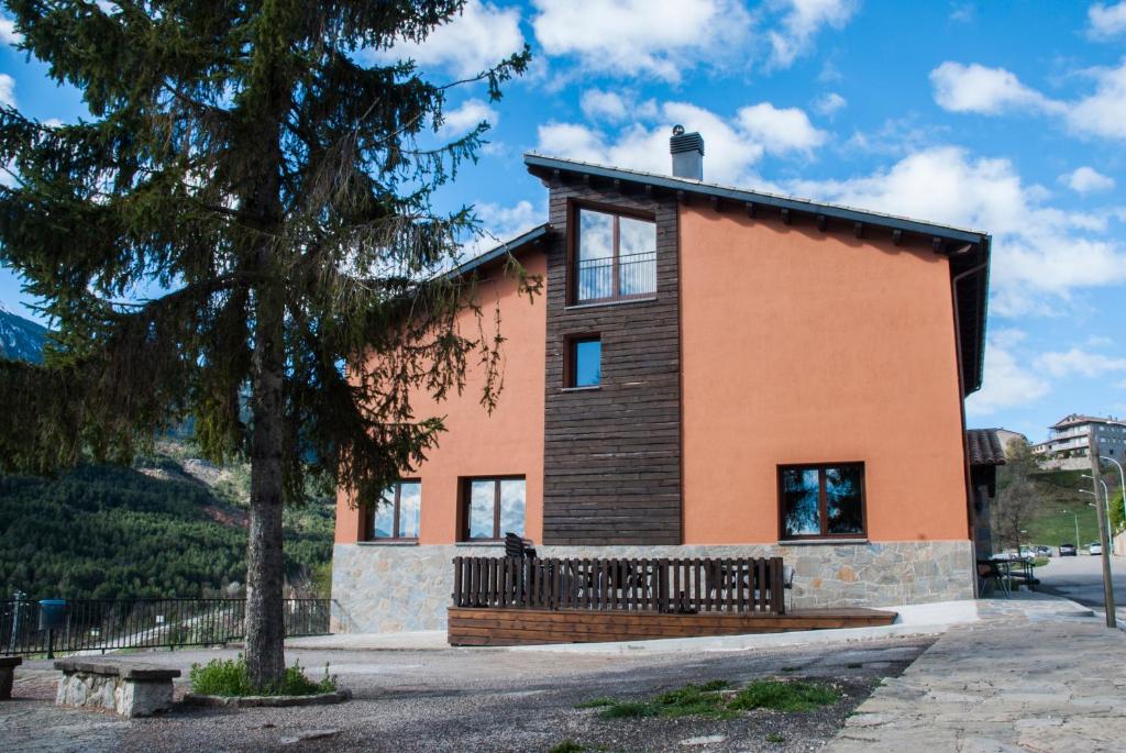 uma casa com uma árvore em frente em Alberg Cal Manel em Saldés