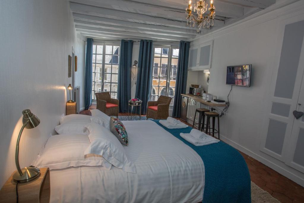 ein Schlafzimmer mit einem großen Bett mit einer blauen Decke in der Unterkunft Berceau Henri II in Le Mans