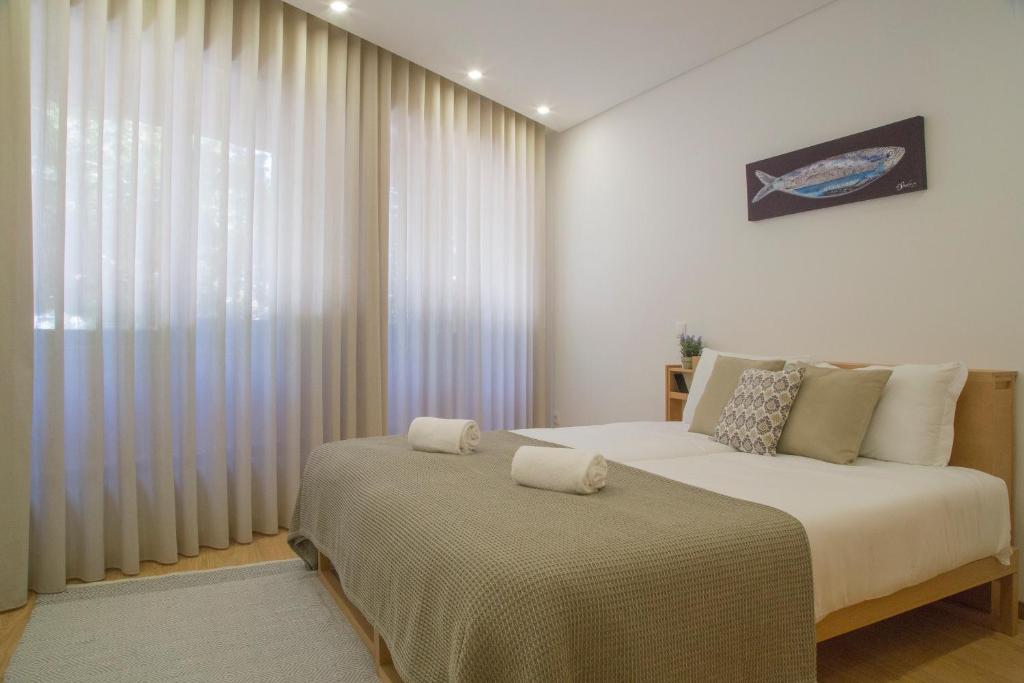 a bedroom with a bed and a large window at Spot Apartments Trindade in Porto