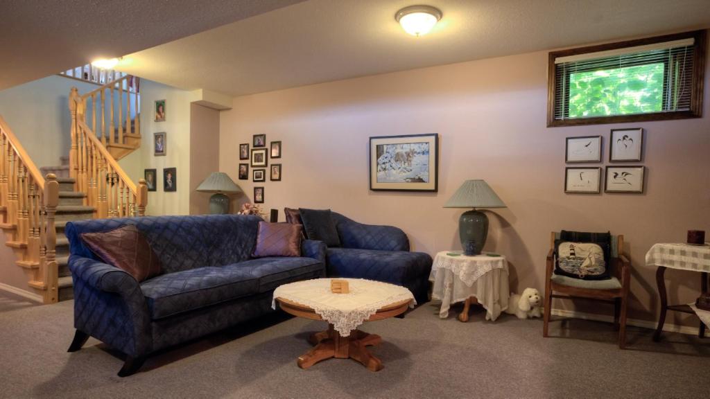 Hummingbird Bed and Breakfast في كليرووتر: غرفة معيشة مع أريكة زرقاء وطاولة