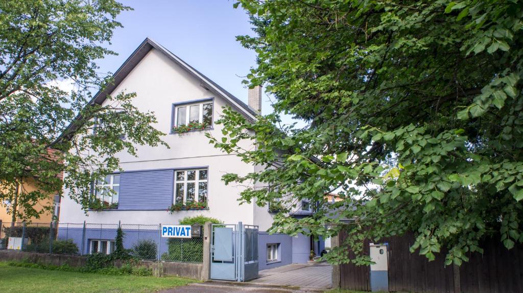 une maison blanche avec un garage bleu dans l'établissement Privat HOTOS, à Liptovský Mikuláš