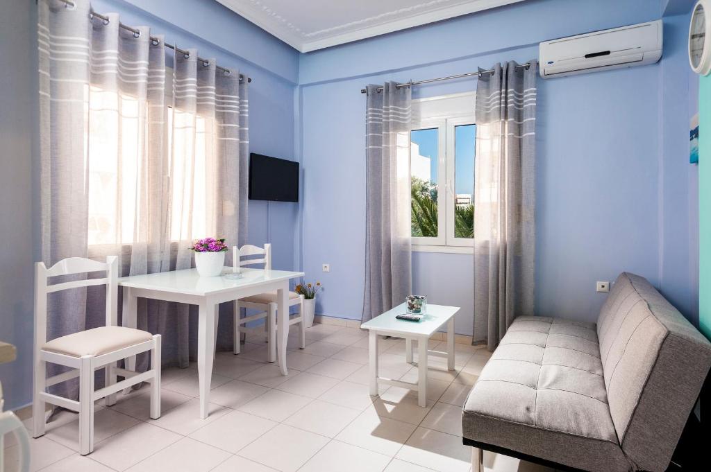 sala de estar con paredes azules, mesa y sofá en Eleni Apartments, en La Canea
