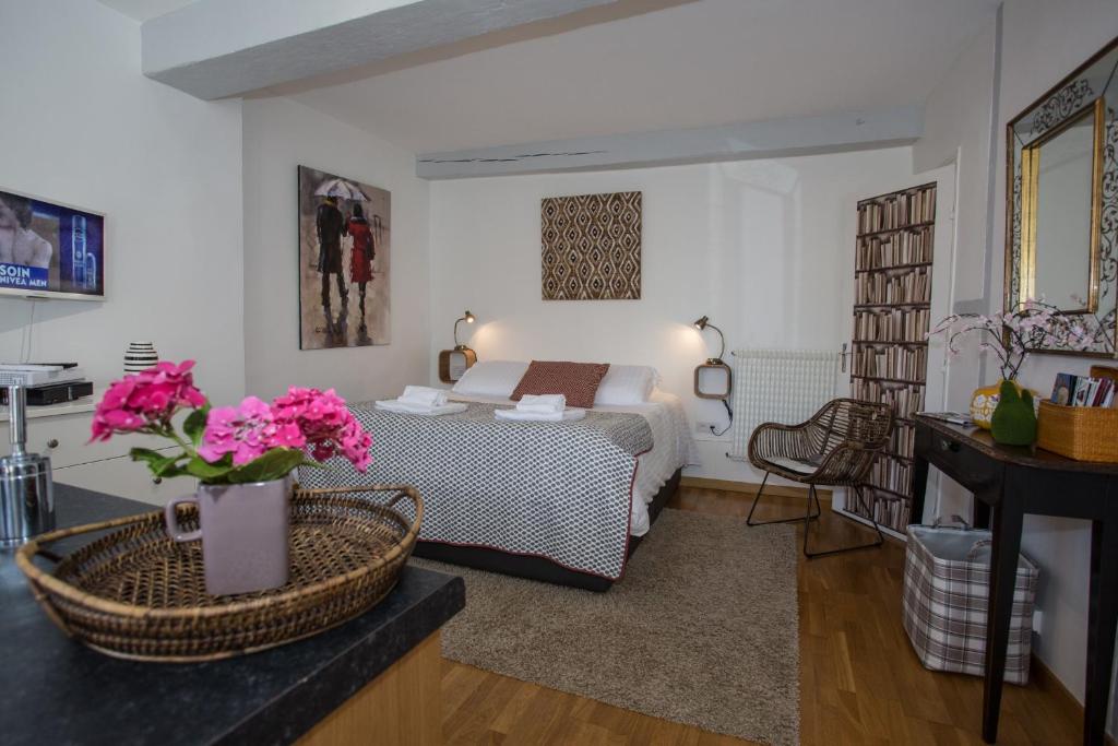 a bedroom with a bed and a table with flowers at L'Hallai du Roy in Le Mans