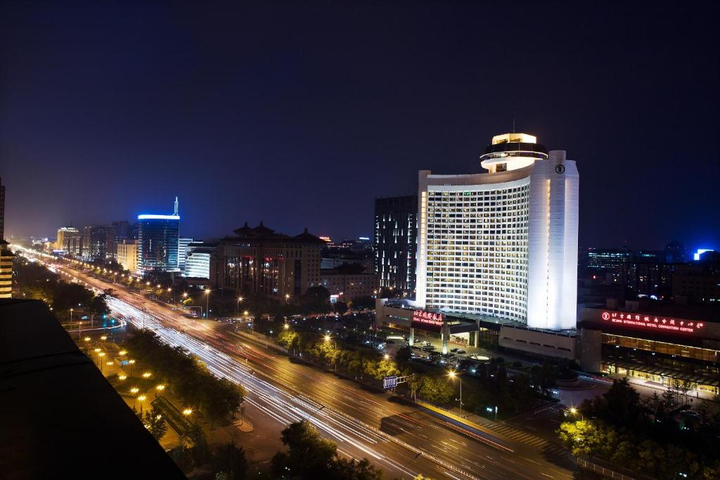 uma cidade iluminada à noite com trânsito numa rua em Beijing International Hotel em Pequim