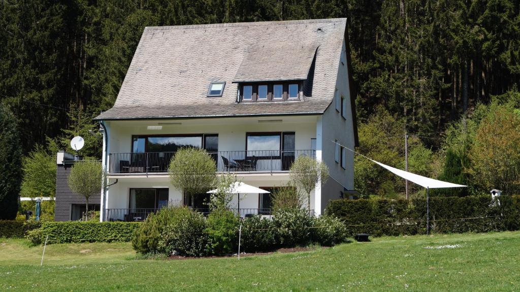 een groot wit huis met een dak bij Landhaus Mettenberg in Eslohe