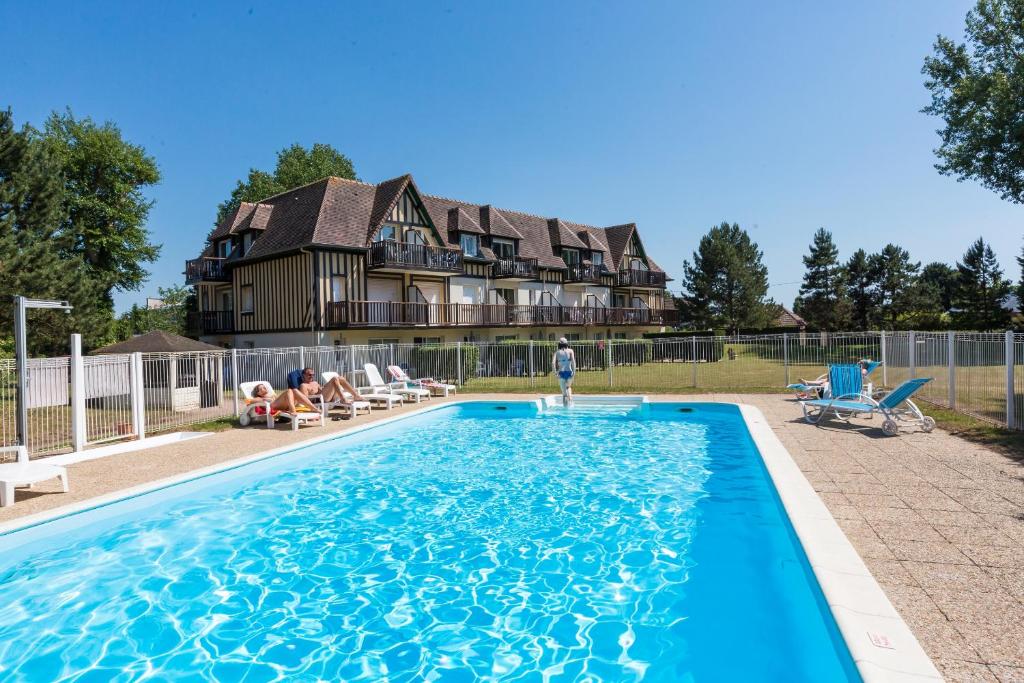 a large swimming pool in front of a house at Résidence Goélia Green Panorama in Cabourg