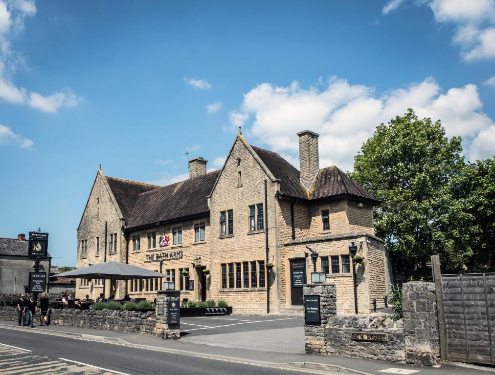 a large stone building on the corner of a street at The Bath Arms Hotel in Cheddar