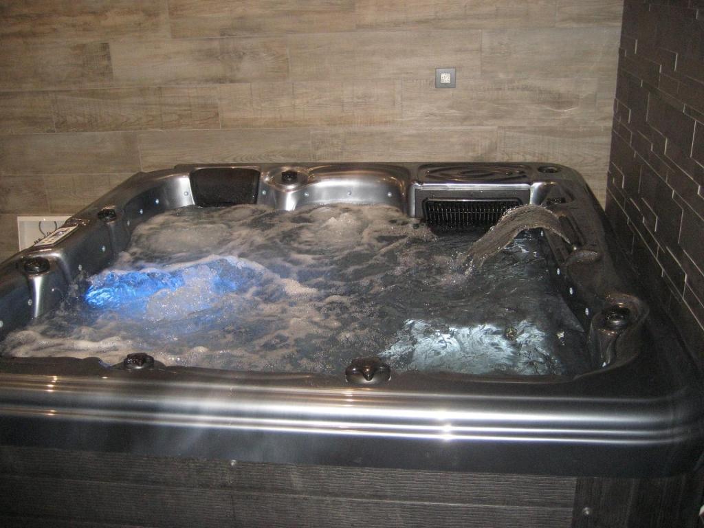 a metal bath tub with a water fountain at Logis de la Licorne in La Ferrière