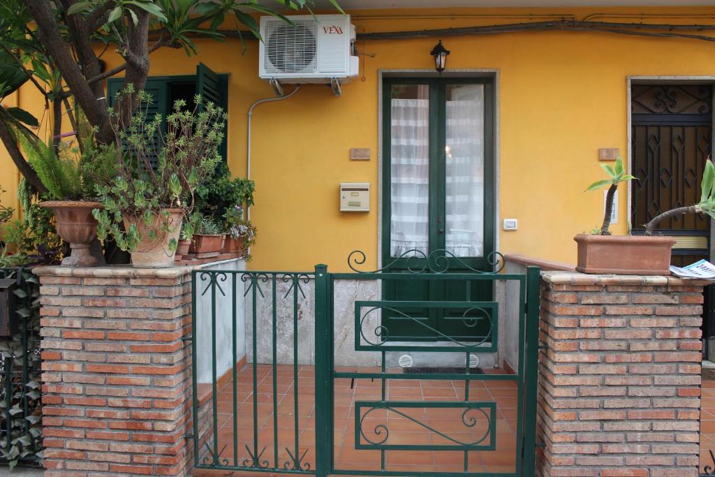 a house with a green gate and a door at Casa vacanze "Terra del sole" in Taormina