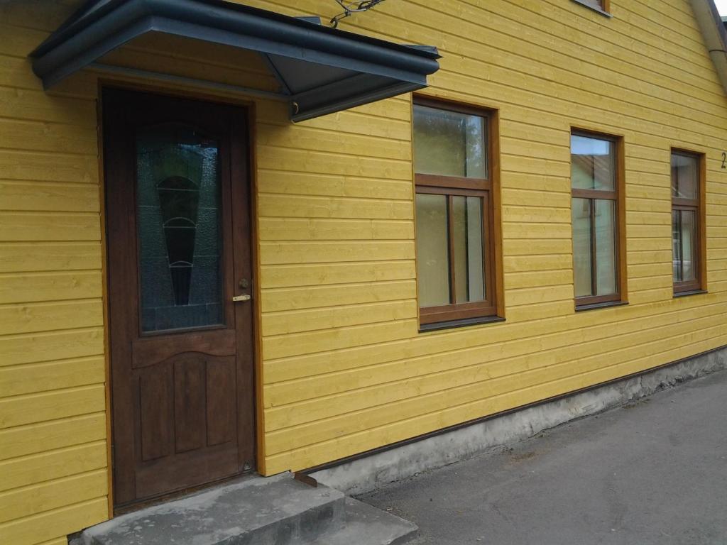 Casa amarilla con puerta y ventanas de madera en Jaani 2-1 Apartment en Pärnu