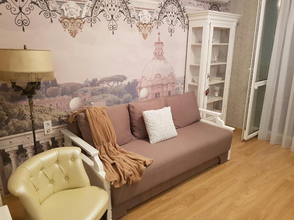 ein Wohnzimmer mit einem Sofa und einem Stuhl in der Unterkunft Comfort Apartment on Bogdanivska street 7b in Kiew