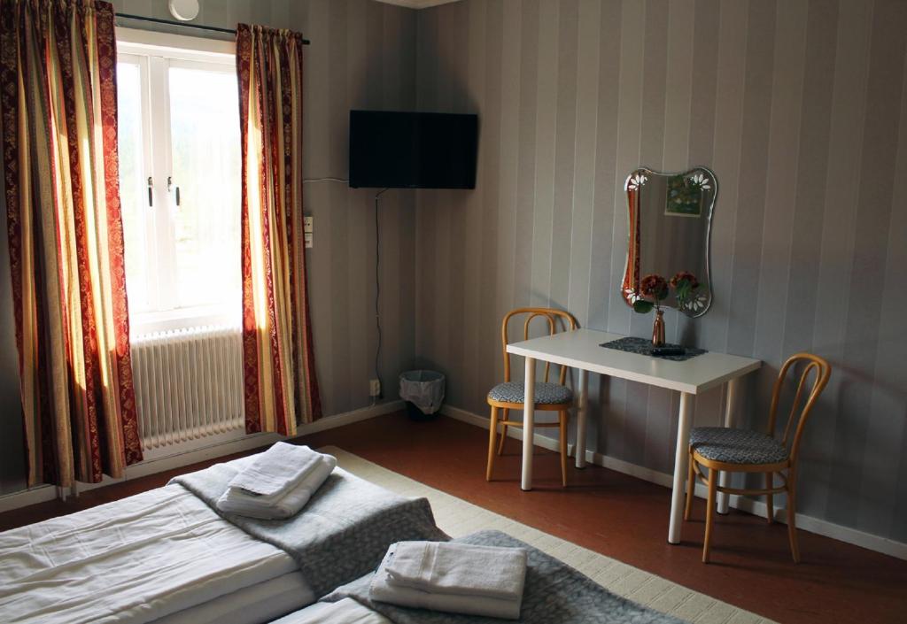 een slaapkamer met een bed en een tafel met een spiegel bij Ammarnäsgården Fjällhotell och Vandrarhem in Ammarnäs