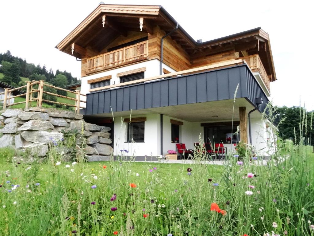 a house in the middle of a field with flowers at Appartement Hoamatgfühl in Flachau