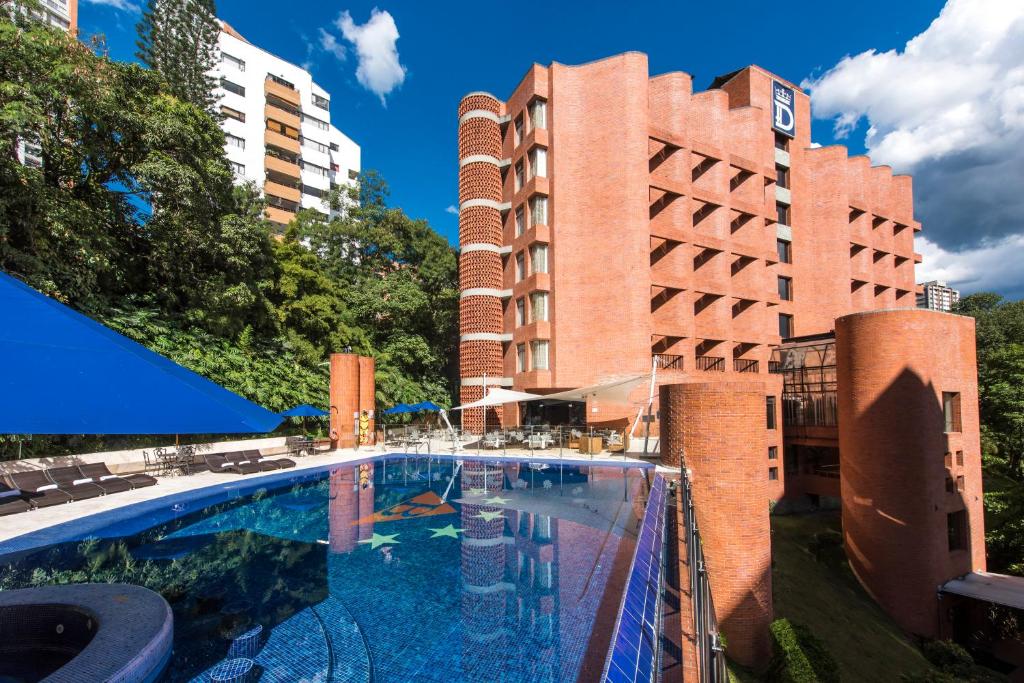 a large swimming pool in front of a building at Hotel Dann Carlton Belfort Medellin in Medellín