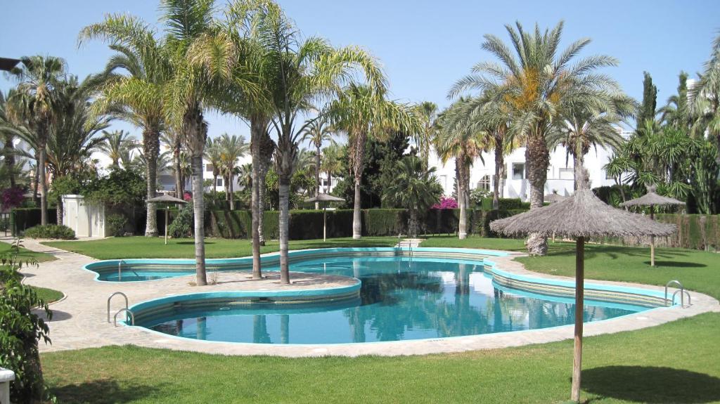 - une piscine avec des palmiers dans un complexe dans l'établissement Apartment Puerto Rey, à Vera