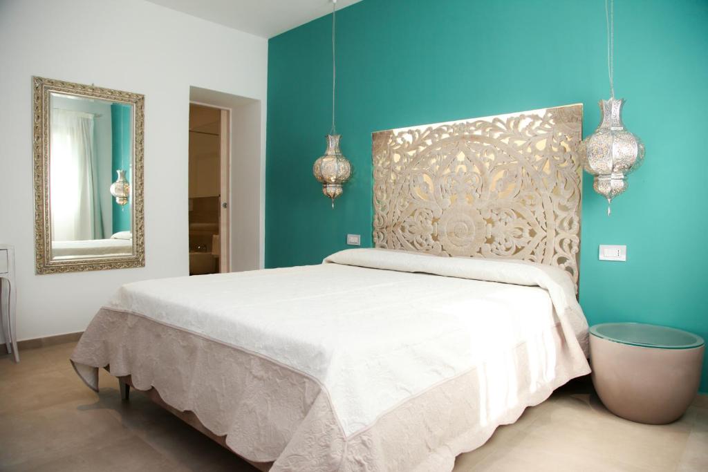 um quarto com uma cama branca e um espelho em Hypnos Boutique Hotel em San Teodoro