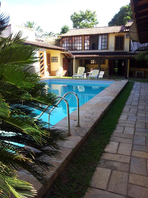 a swimming pool in front of a house at Pousada Alto da Pontinha in Araruama