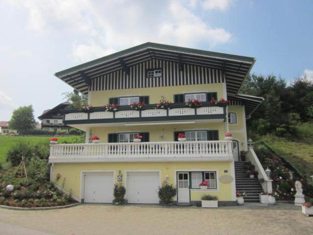 a large yellow house with a balcony on top of it at Appartement Bergblick I in Faistenau