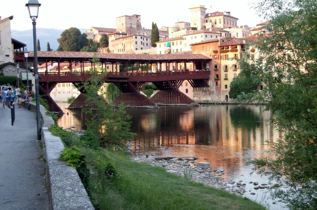 un puente sobre un río en una ciudad con edificios en Luxury House B&B, en Bassano del Grappa