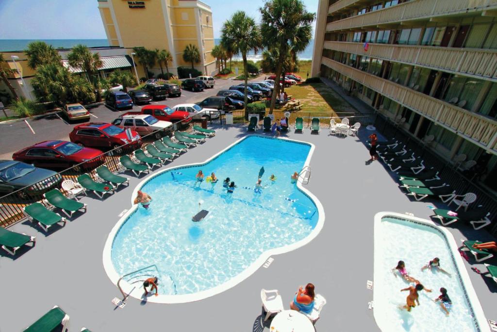 einen Blick über den Pool auf einem Parkplatz in der Unterkunft Oceanfront Viking Motel in Myrtle Beach