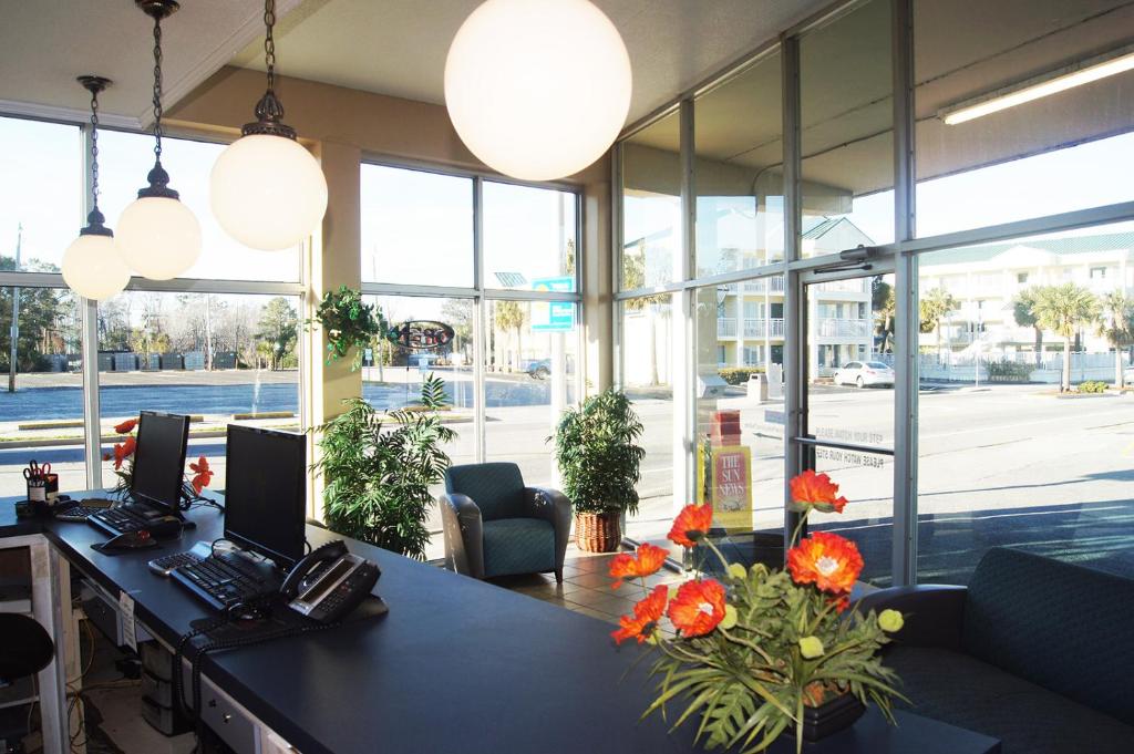 ein Büro mit einem Schreibtisch mit Blumen darauf in der Unterkunft Oceanfront Viking Motel in Myrtle Beach