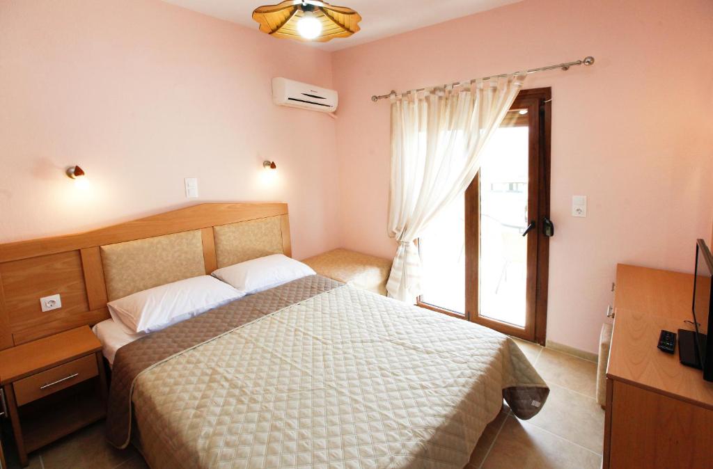 a bedroom with a large bed and a window at Asteras Kalives in Skala Potamias