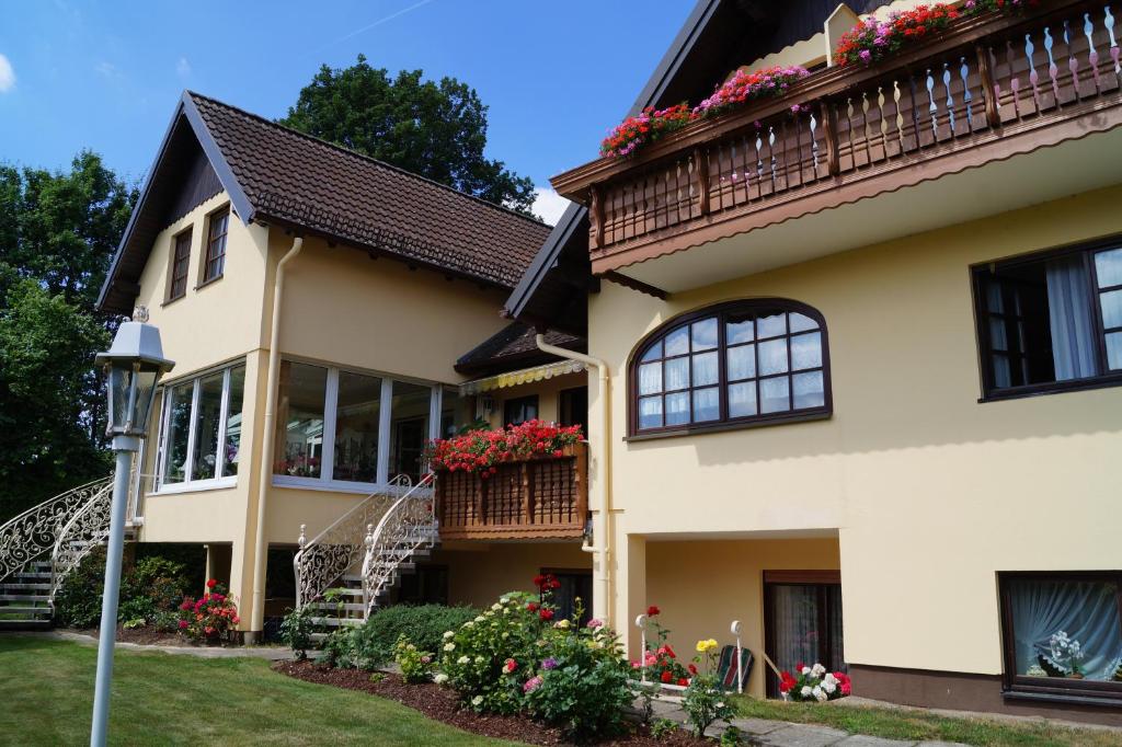 una casa con balcón y flores. en Pension Kordula Straub, en Waldfenster