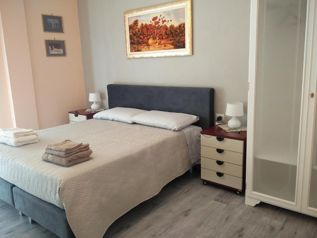 1 Schlafzimmer mit 2 Betten, einer Kommode und einem Gemälde in der Unterkunft Julia B&B in Crotone