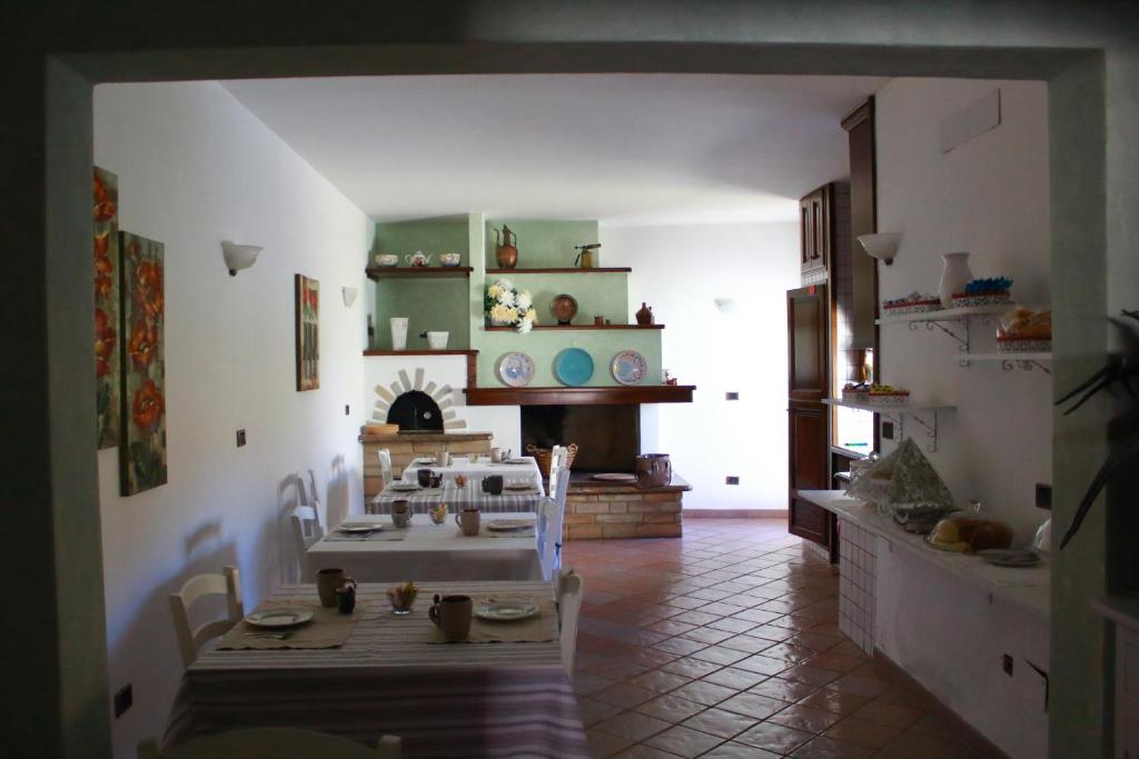 un soggiorno con diversi tavoli e un camino di Guest House Li Minnanni a Olbia