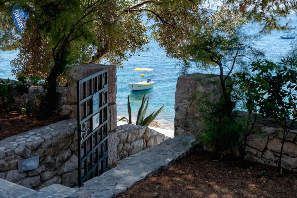 a gate leading to a boat in the water at Pine Beach Villa in Hvar