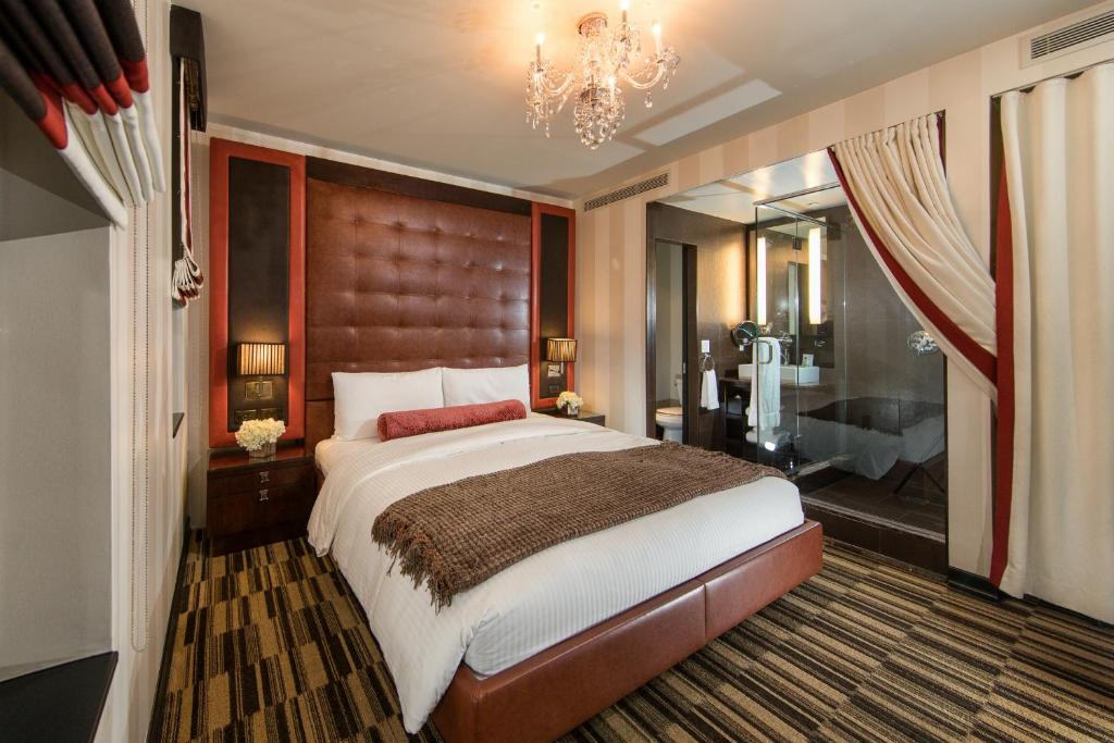 a bedroom with a large bed and a bathroom at Sanctuary Hotel New York in New York
