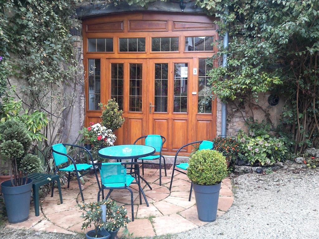 una mesa y sillas frente a una puerta de madera en Le Chanois, en Fontaine