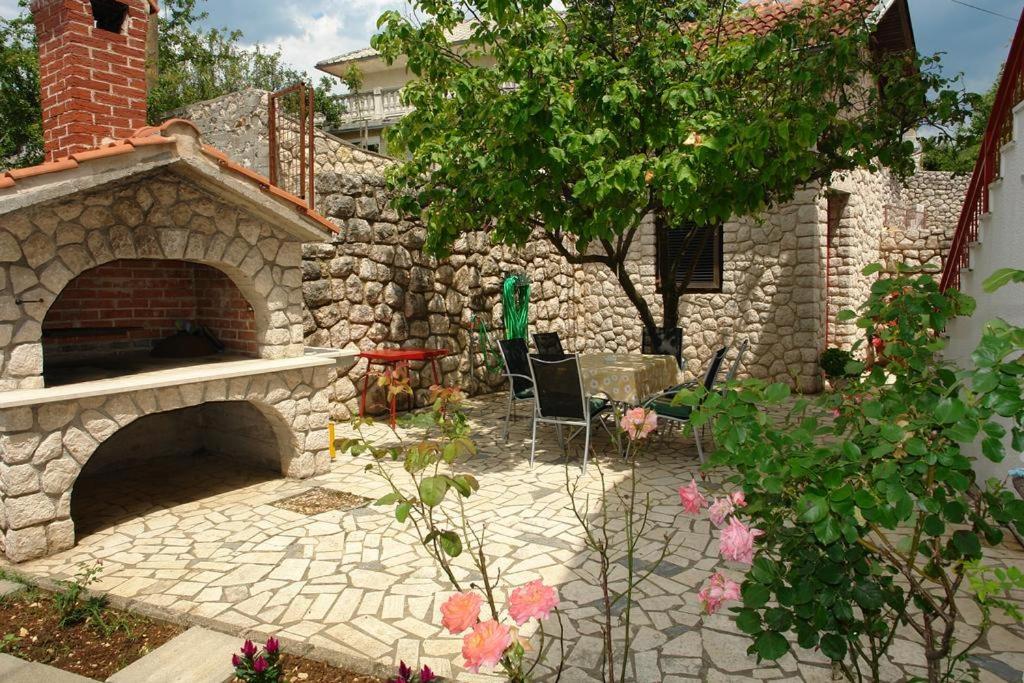 a stone patio with a brick oven in a yard at Villa Nina in Novi Vinodolski