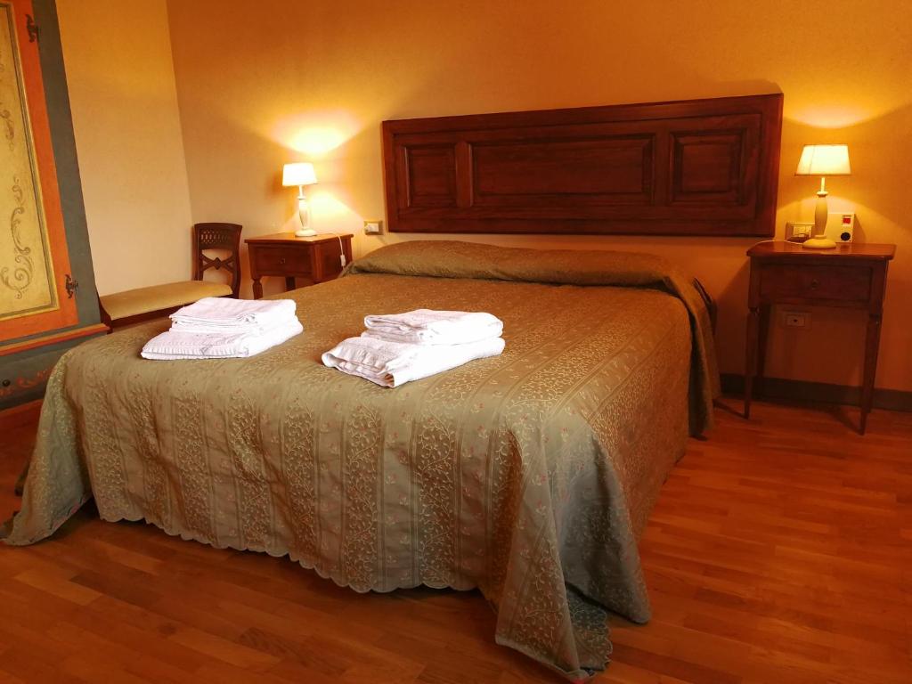 pokój hotelowy z łóżkiem i ręcznikami w obiekcie Residence il Poggiolino w mieście Montecarelli