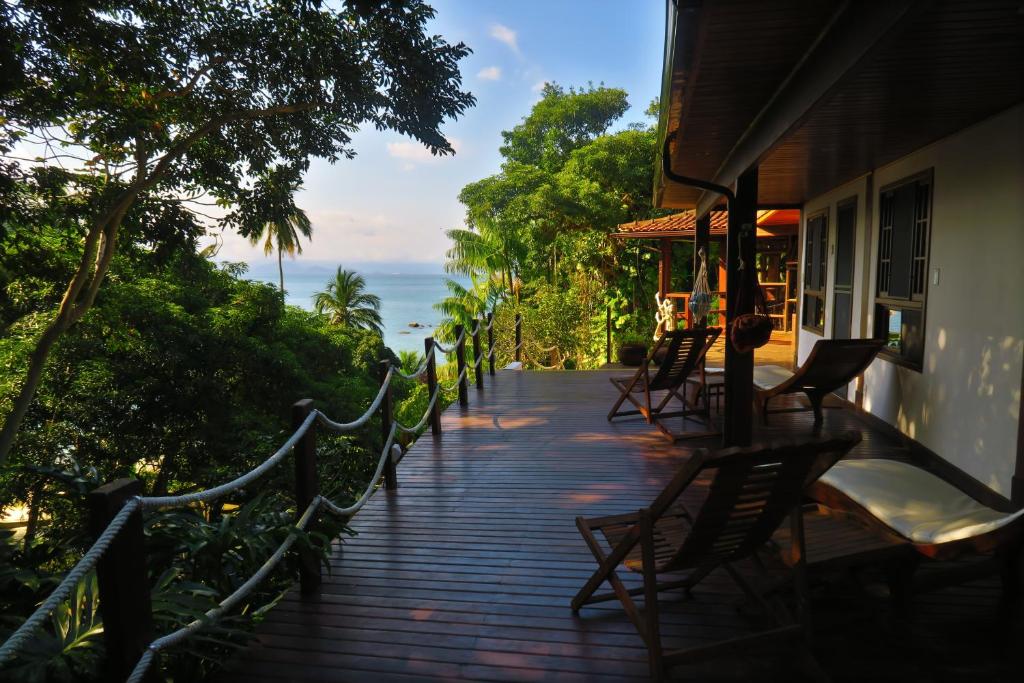 a porch of a building with chairs and the ocean at Atlantica Jungle Lodge in Abraão