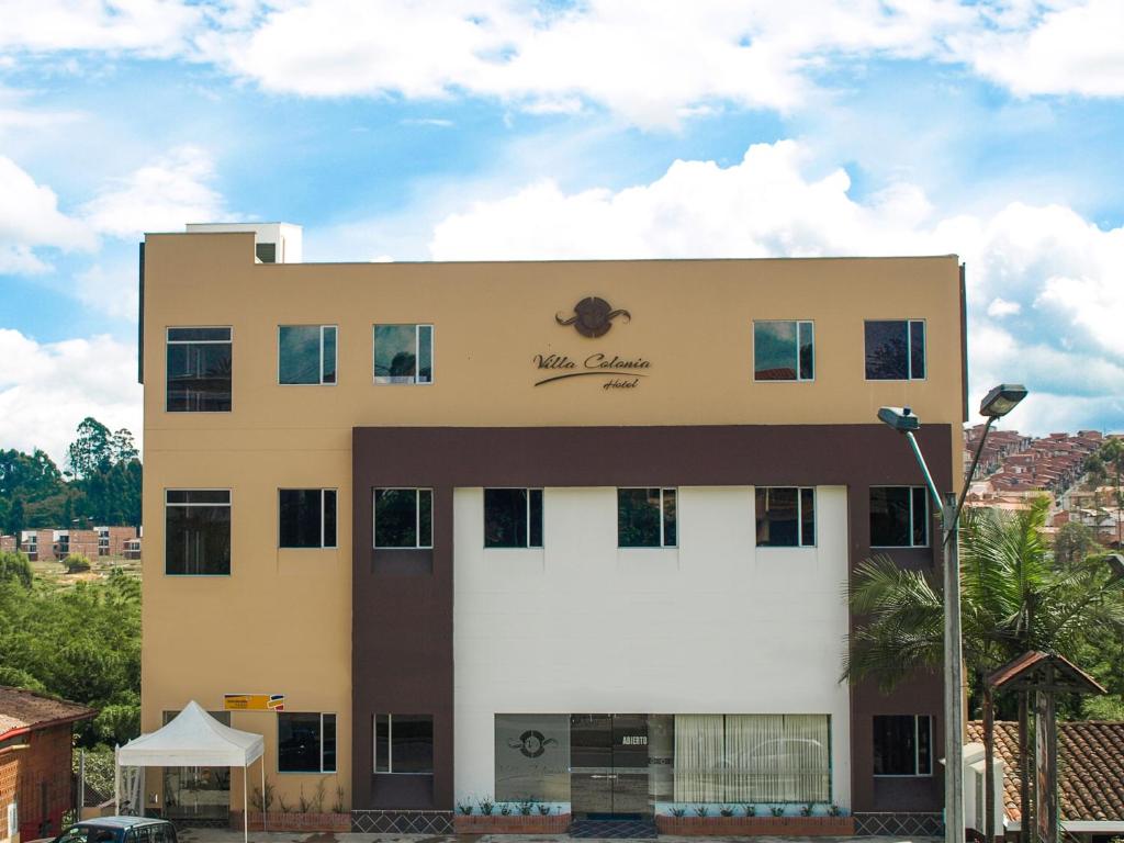 a building with a sign on the side of it at Hotel Villa Colonia in Marinilla