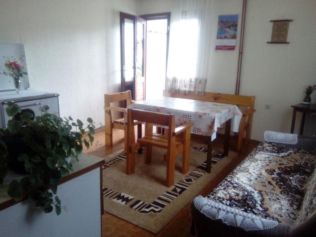 ein Wohnzimmer mit einem Tisch, Stühlen und einem Sofa in der Unterkunft Guesthouse Andrea A in Žabljak