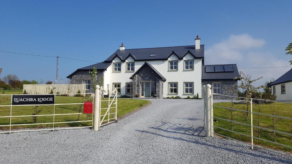 una casa bianca con un cancello davanti di Luachra Lodge a Killarney