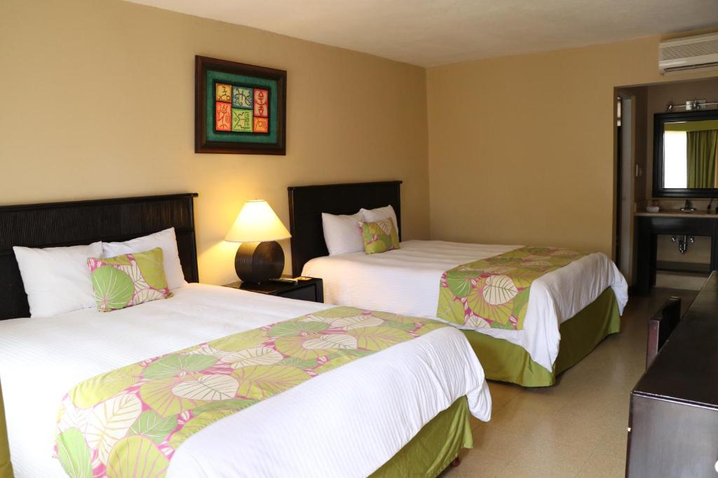Un pat sau paturi într-o cameră la Coco Beach Hotel